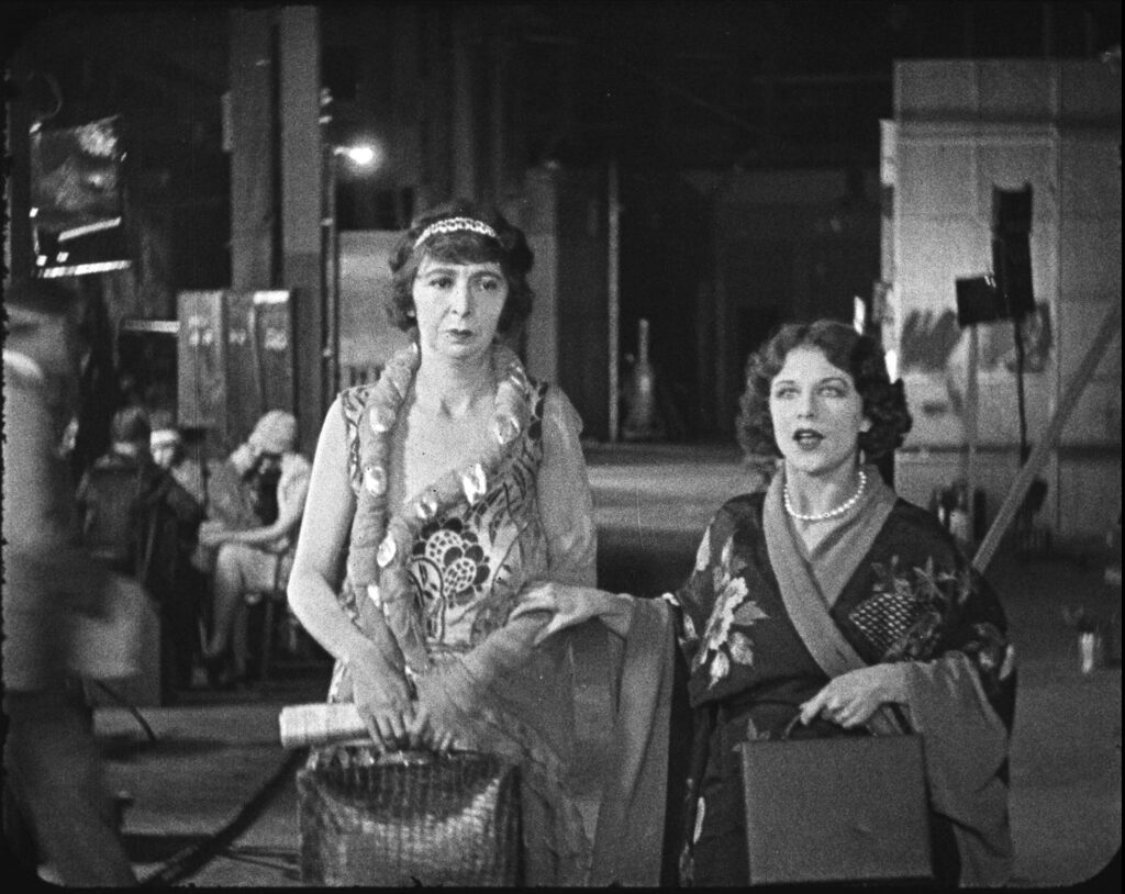 Gale Henry and Shirley Mason walk through the movie studio in the 1927 film STRANDED